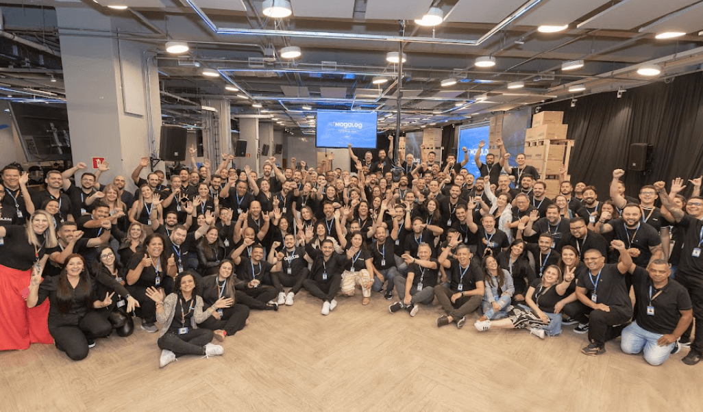 Equipe reunida ao lado externo de um centro de distribuição em construção